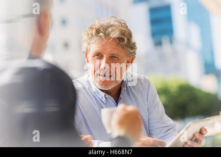 Geschäftsleute, die Kaffee trinken mit digital-Tablette in städtischen Straßencafé Stockfoto