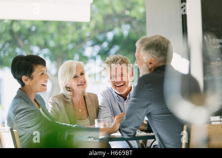 Lächelnde Paare sprechen und Essen am Tisch im restaurant Stockfoto