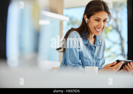 Lächelnde Frau mit digital-Tablette und Kopfhörer Stockfoto