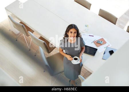 Porträt lächelnd Geschäftsfrau Kaffeetrinken im Konferenzraum Stockfoto