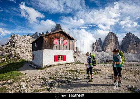 Wanderer und Hütte neben Rifugio Locatelli, Tre Cime di Lavaredo, Sextener Dolomiten, Südtirol, Italien. Stockfoto