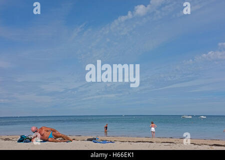 Ein Mann in seinen Sechzigern sonnt sich am Strand in Quiberon, Bretagne, Frankreich Stockfoto