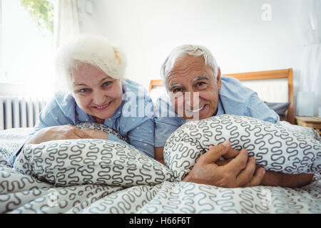 Porträt von älteres paar lächelnd auf Bett Stockfoto