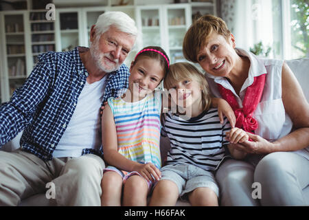 Porträt von Großeltern mit ihren Enkelkindern sitzen Stockfoto