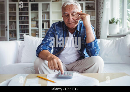 Gespannten senior woman, Kontrolle der Rechnungen Stockfoto
