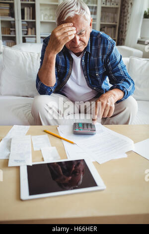 Gespannten senior woman, Kontrolle der Rechnungen Stockfoto