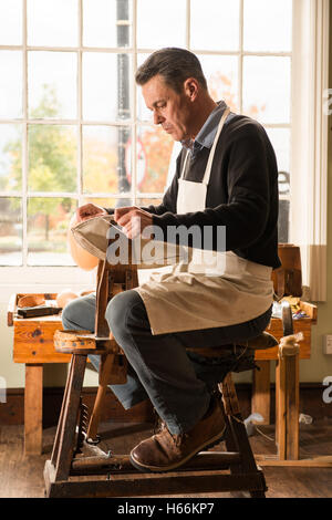 Eine traditionelle Ball Stitcher macht einen Leder-Rugby-Ball in der Webb Ellis Rugby Football Museum, Rugby, Warwickshire, UK. Stockfoto