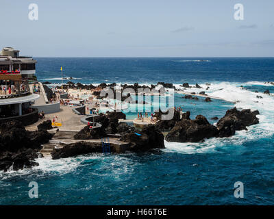 Touristen und Einheimische genießen Sie ein Bad in der freien Atlantik natürliche Meerwasserpools von Porto Moniz, Madeira Stockfoto