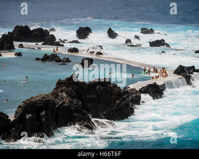 Touristen und Einheimische genießen Sie ein Bad in der freien Atlantik natürliche Meerwasserpools von Porto Moniz, Madeira Stockfoto