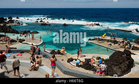 Touristen und Einheimische genießen Sie ein Bad in der freien Atlantik natürliche Meerwasserpools von Porto Moniz, Madeira Stockfoto