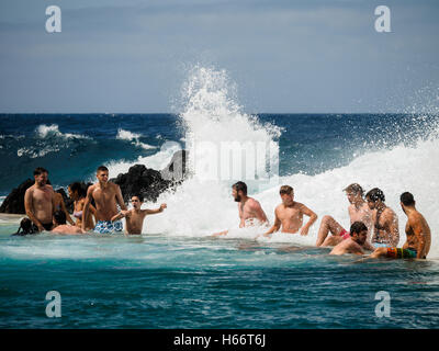 Touristen und Einheimische genießen Sie ein Bad in der freien Atlantik natürliche Meerwasserpools von Porto Moniz, Madeira Stockfoto