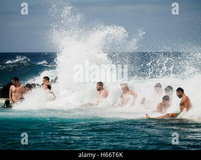 Touristen und Einheimische genießen Sie ein Bad in der freien Atlantik natürliche Meerwasserpools von Porto Moniz, Madeira Stockfoto