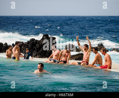 Touristen und Einheimische genießen Sie ein Bad in der freien Atlantik natürliche Meerwasserpools von Porto Moniz, Madeira Stockfoto