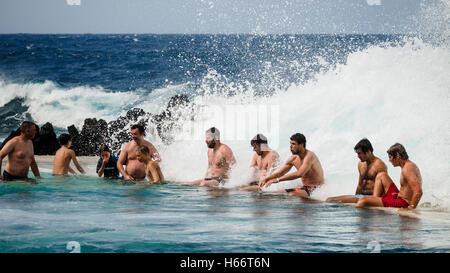 Touristen und Einheimische genießen Sie ein Bad in der freien Atlantik natürliche Meerwasserpools von Porto Moniz, Madeira Stockfoto