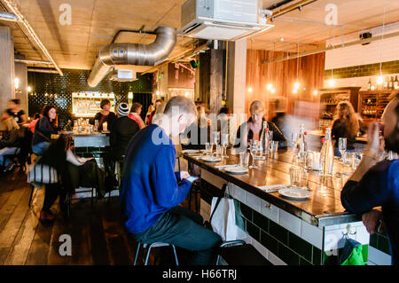 Kunden in einem gut besuchten Restaurant in Belfast Stockfoto