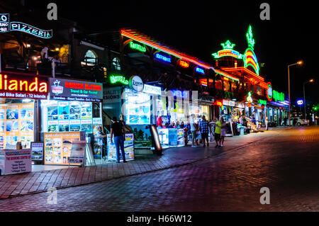 Geschäfte, Bars und Restaurants in Hisaronu, Oludeniz, Fethiye, Türkei mit Neon und LED Schilder in der Nacht. Stockfoto