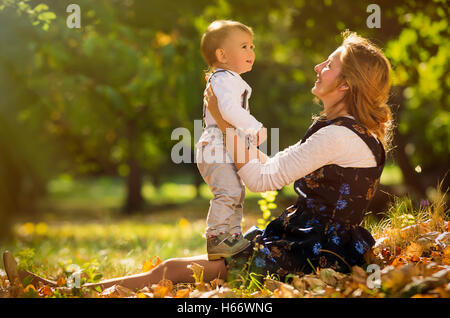 Mutter umarmt und mit ihrem Sohn im Park spielen. Stockfoto