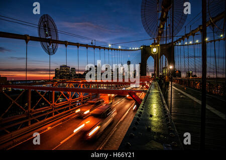 Autos, Verkehr auf der Brooklyn Bridge, East River, am Abend, Blick auf den Sonnenuntergang Skyline von Lower Manhattan, New York City Stockfoto