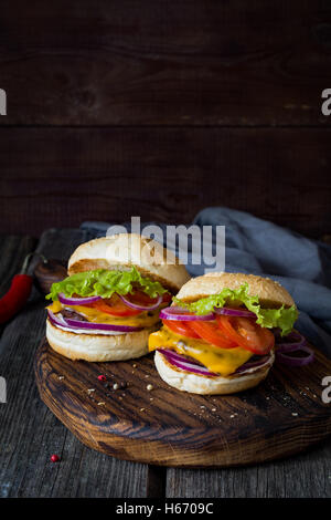 Zwei saftige Burger auf Schneidbrett aus Holz. Nahaufnahme Stockfoto
