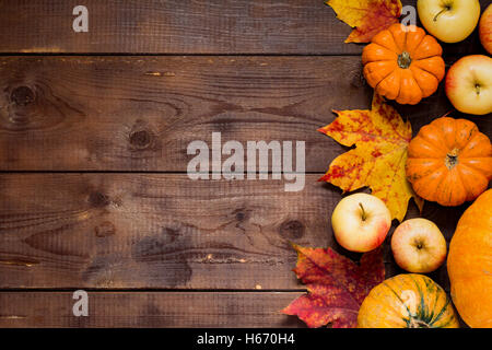 Thanksgiving-Hintergrund: Äpfel, Kürbisse und Laub auf hölzernen Hintergrund. Platz für Text zu kopieren. Stockfoto