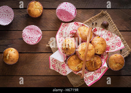 Obst-Muffins mit Muskat und Piment in einem Weidenkorb auf einem hölzernen Hintergrund. Ansicht von oben Stockfoto