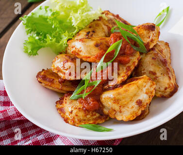 Köstlichen Ravioli mit Tomaten-Sauce und grünen Zwiebeln. Stockfoto