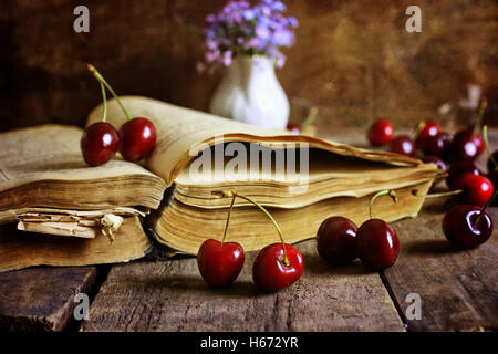 Retro-Buch auf hölzernen Hintergrund und Cherry berry Stockfoto