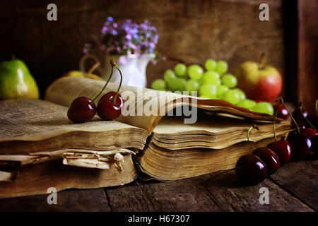 Retro-Buch auf hölzernen Hintergrund und Cherry berry Stockfoto