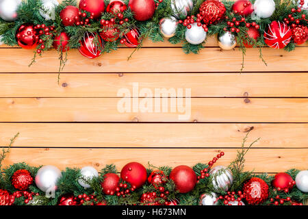 Saisonale Hintergrund mit Pinien und Beere Girlande mit Weihnachtsschmuck aufgereiht hinein Stockfoto