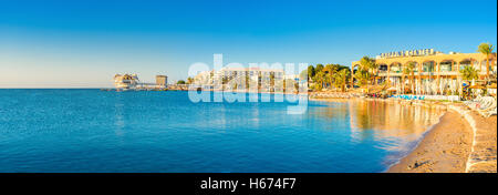 Der gemütliche Strand mit Straßencafés und Bars und die modernen Dive Station auf dem Hintergrund, Eilat, Israel. Stockfoto