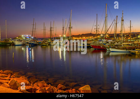 Die schöne Aussicht auf den Hafen am Abend, voller Yachten und Boote, mit dem roten Dämmerung Himmel im Hintergrund, Eilat Stockfoto