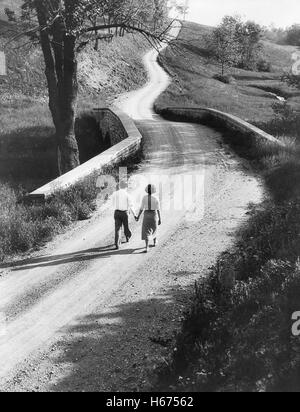 Hintere Ansicht Porträt des Paares zu Fuß hinunter ländliche Straße, Pennsylvania, USA, Philip D. Gendreau für Farm Security Administration, 1930 Stockfoto