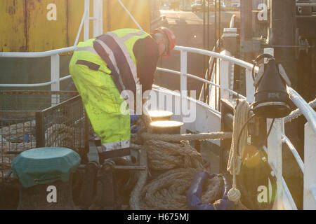 Besatzung, die Wicklung Seil um Poller auf Calmac Ferry, wie es bei Mallaig Dock am Ende seiner Überfahrt von Isle Of Skye dockt Stockfoto