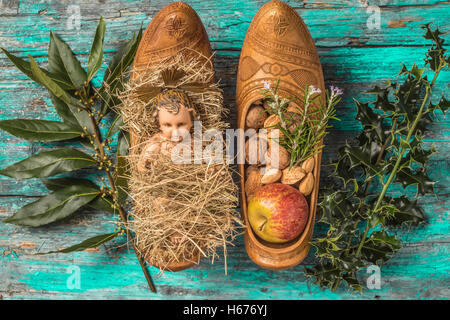 Weihnachtszeit, antike Figur des Jesuskindes und Angebote im traditionellen Landwirt verstopfen auf rustikalen Hintergrund Stockfoto