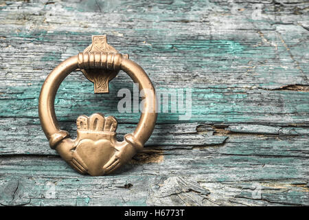 Claddagh, irische Symbol der Liebe, Freundschaft und Loyalität im alten hölzernen Hintergrund Stockfoto