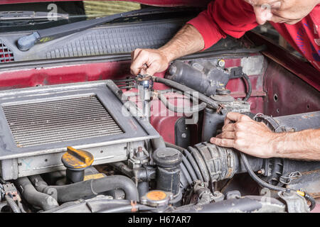 Mechaniker arbeiten am Motor eines Autos in einer garage Stockfoto