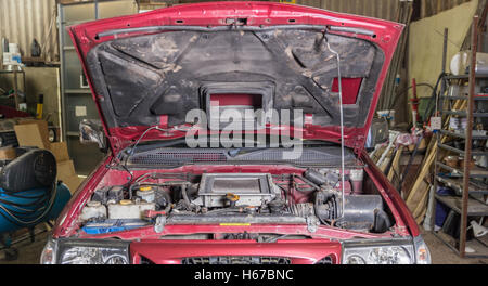 Auto in Garage mit Haube, repariert oder gewartet werden. Stockfoto