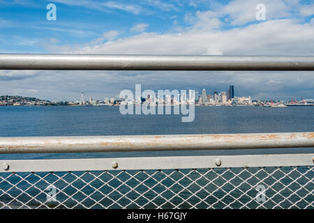 Metallgeländer umrahmen die Skyline von Seattle und Teil des Queen Anne Hill. Schuss von Alki Beach genommen. Stockfoto