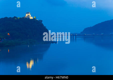 In der Nähe von Dämmerung weit Inuyama Burg beleuchtet von Scheinwerfern über dem Kiso-Fluss in der Abenddämmerung in der Präfektur Gifu, Japan Stockfoto