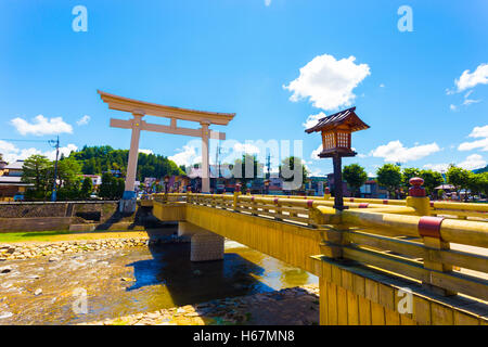 Übergroße Torii-Tor markiert den Eingang zum abgewinkelten Miyamae-Bashi-Brücke über den Fluss Miya-Gawa, der durchschneidet Takayama v Stockfoto