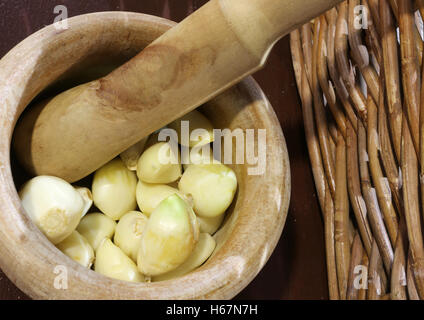 handgefertigte hölzerne Stößel mit Knoblauchzehen, dem Pesto Alla Genovese ein typisch italienisches Gericht vorzubereiten Stockfoto