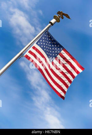 Amerikanische Flagge auf der Pole schwenkte in den Wind vor blauem Himmelshintergrund Stockfoto