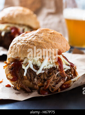 Schweinefleisch-Sandwich mit Kohl Krautsalat obenauf serviert auf Papier gezogen Stockfoto