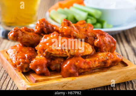 Buffalo Chicken Wing mit Cayenne-Pfeffer-Sauce mit Stangensellerie heiß serviert und Karotten-sticks mit Blauschimmelkäse dressing Stockfoto