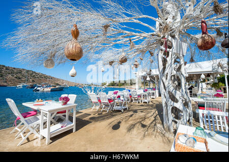 Informelle am Strand sitzen mit dekorativer Baum in einem malerischen touristischen Dorf in der Nähe von Bodrum, Türkei Stockfoto