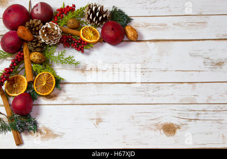 Weihnachts-Potpourri Hintergrund mit Orangen, Trockenobst, Zimtstangen, Muttern mit Platz für textfreiraum auf Holzbrett Stockfoto