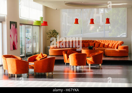 Große orange Sofa und passende Tische und Stühle in der Lobby eines Hotels. Stockfoto