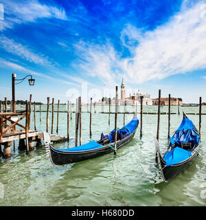 Venedig, Gondeln oder Gondeln auf einem blauen Himmel und San Giorgio Maggiore Kirche Wahrzeichen auf Hintergrund. Italien, Europa. Stockfoto