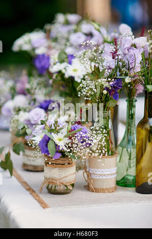 Rustikale Hochzeit Dekor, Provence Stil. Lavendel Strauß Wiesenblumen und Glas Gewürzdosen auf Holztisch Stockfoto