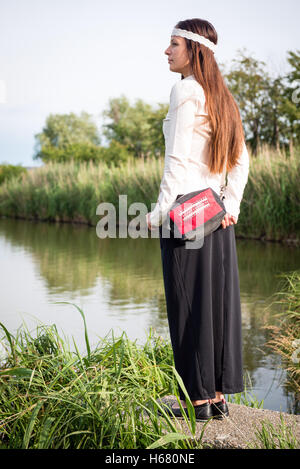 Porträt des jungen Hippie-Frau mit Handtasche stehen am See Stockfoto